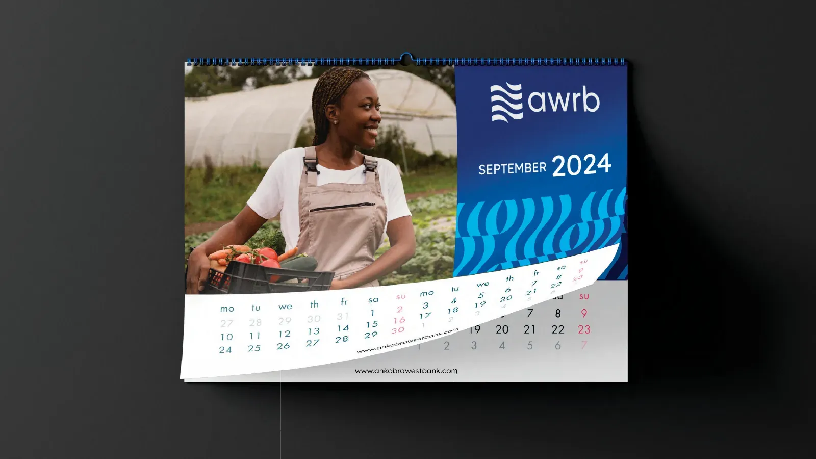 Wall calendar showing a farmer, with the wave graphic and the bank's lockup.