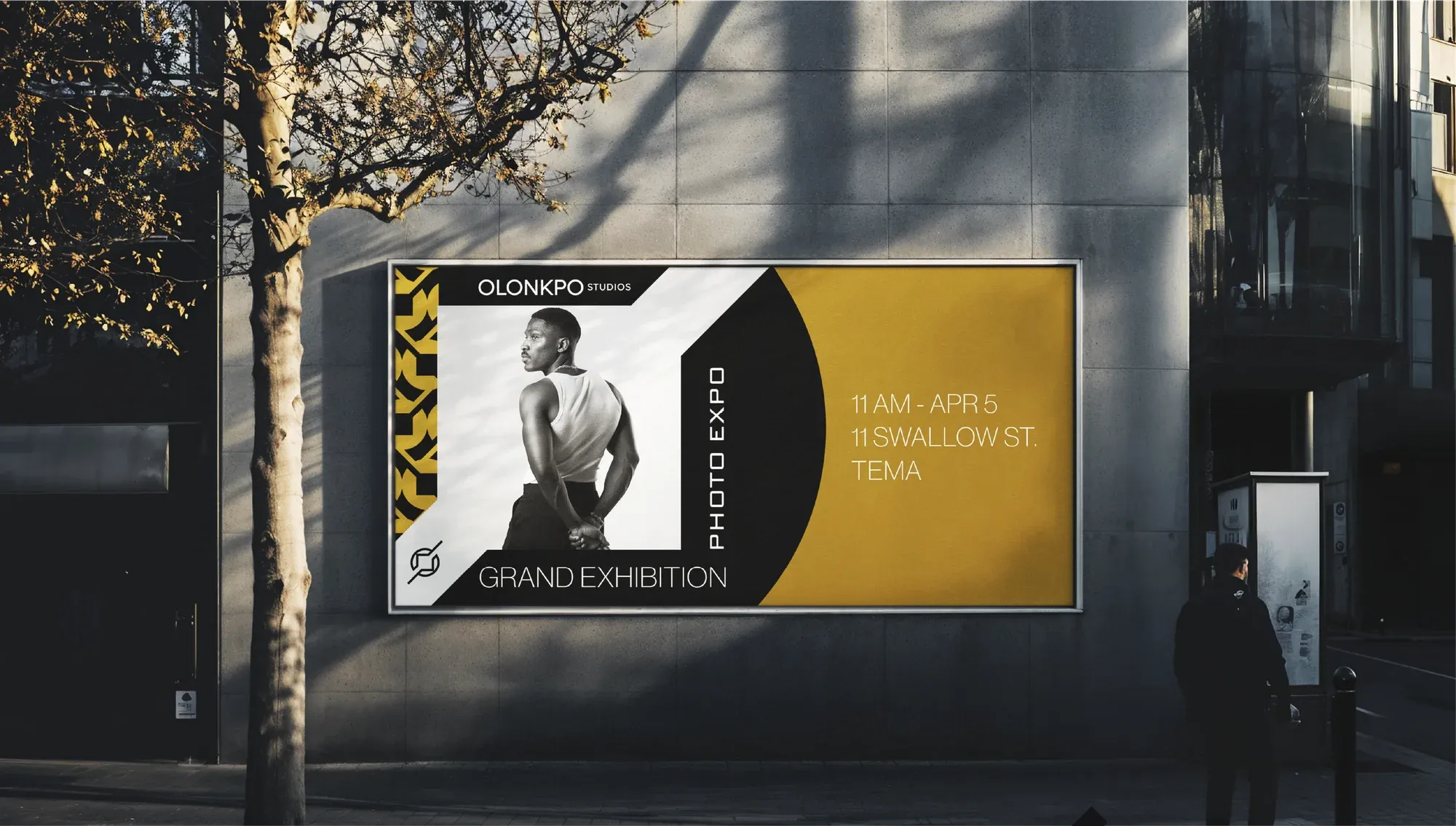A street-side billboard announcing a photography exhibition, gold pattern set against a black-and-white portrait.
