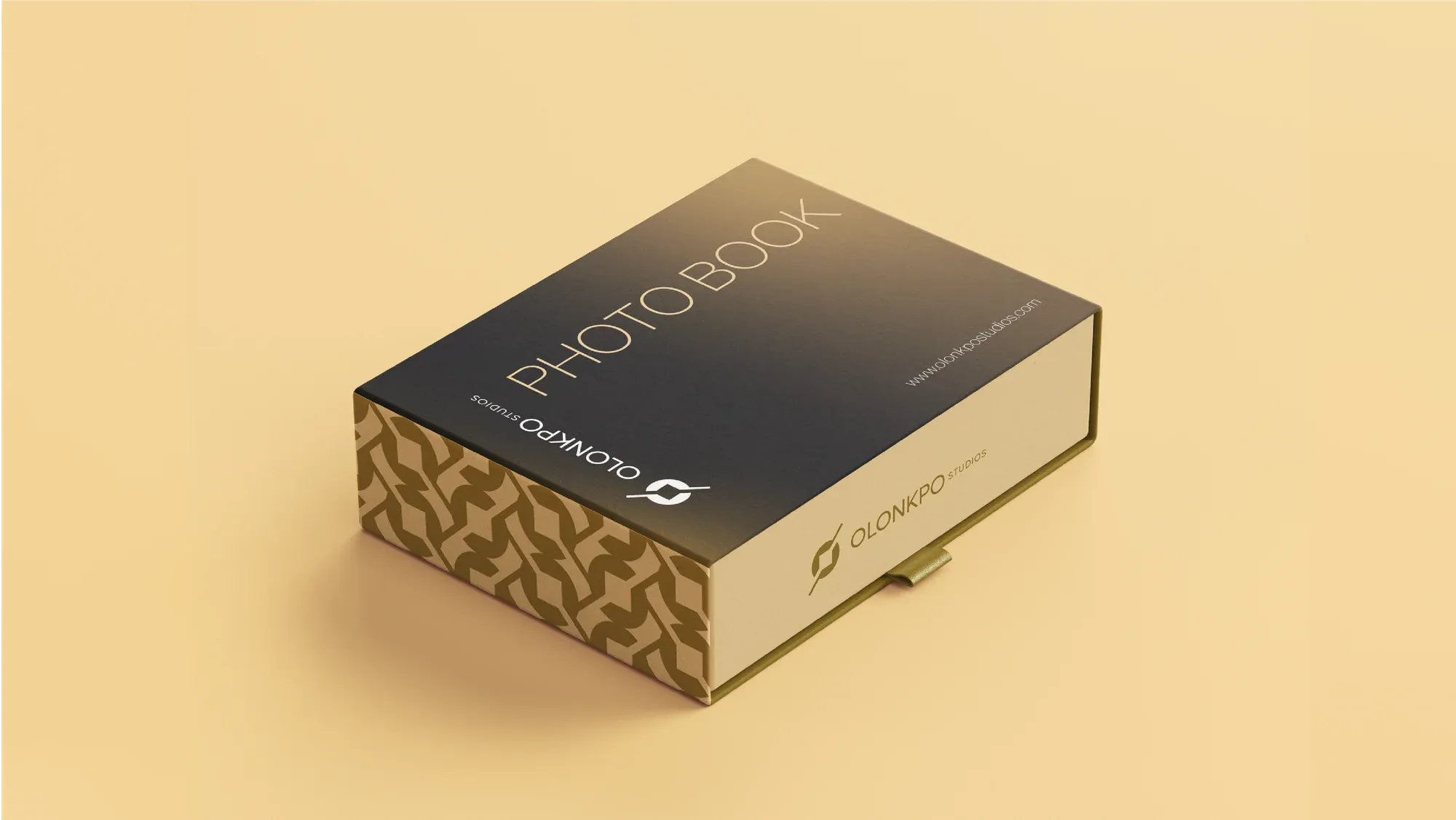 A gold-patterned presentation box for a photo book, shot on a cream field.