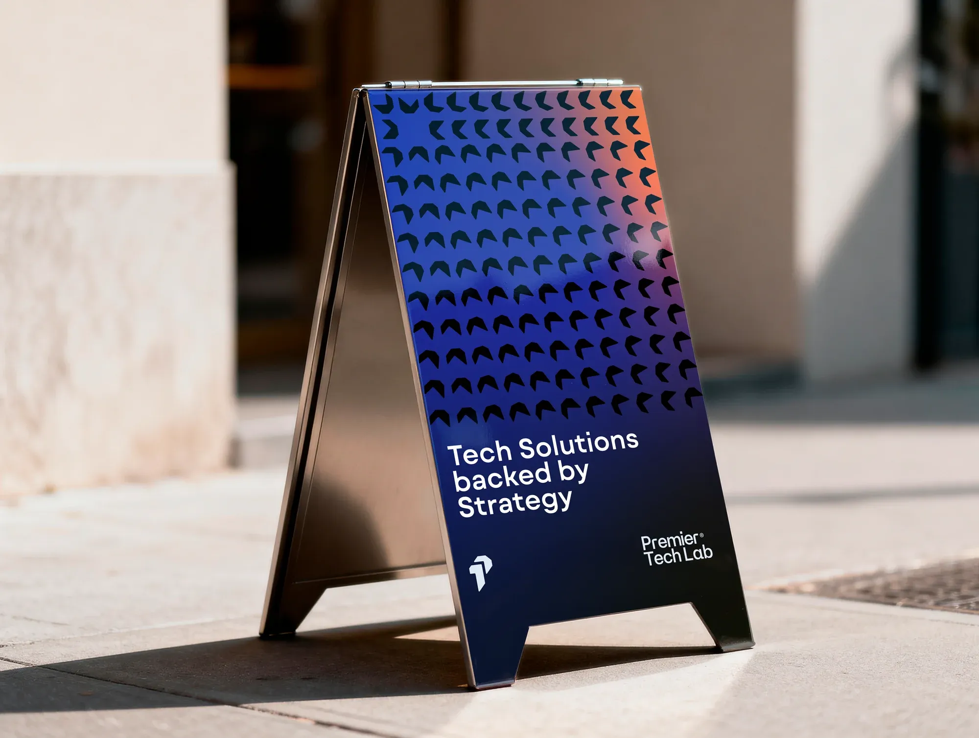 A pavement A-frame in raking sunlight, reading tech solutions backed by strategy.