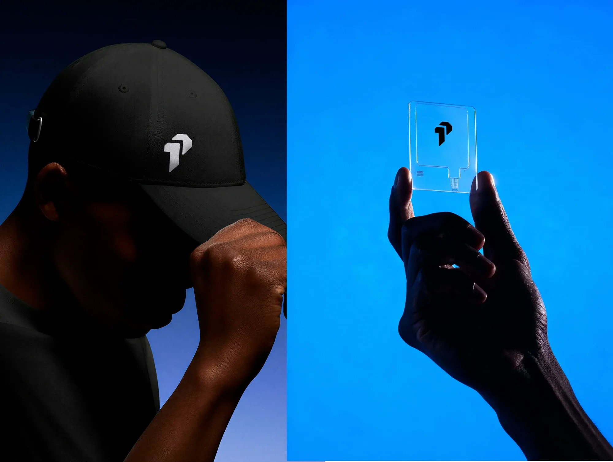 A black embroidered cap beside a hand holding a clear acrylic card, both shot on deep blue.